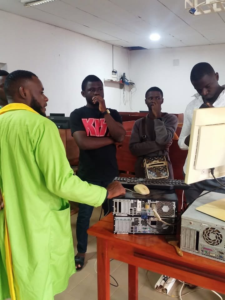 Students practicing computer hardware diagnostics, repair and device setup in a technical maintenance lab
